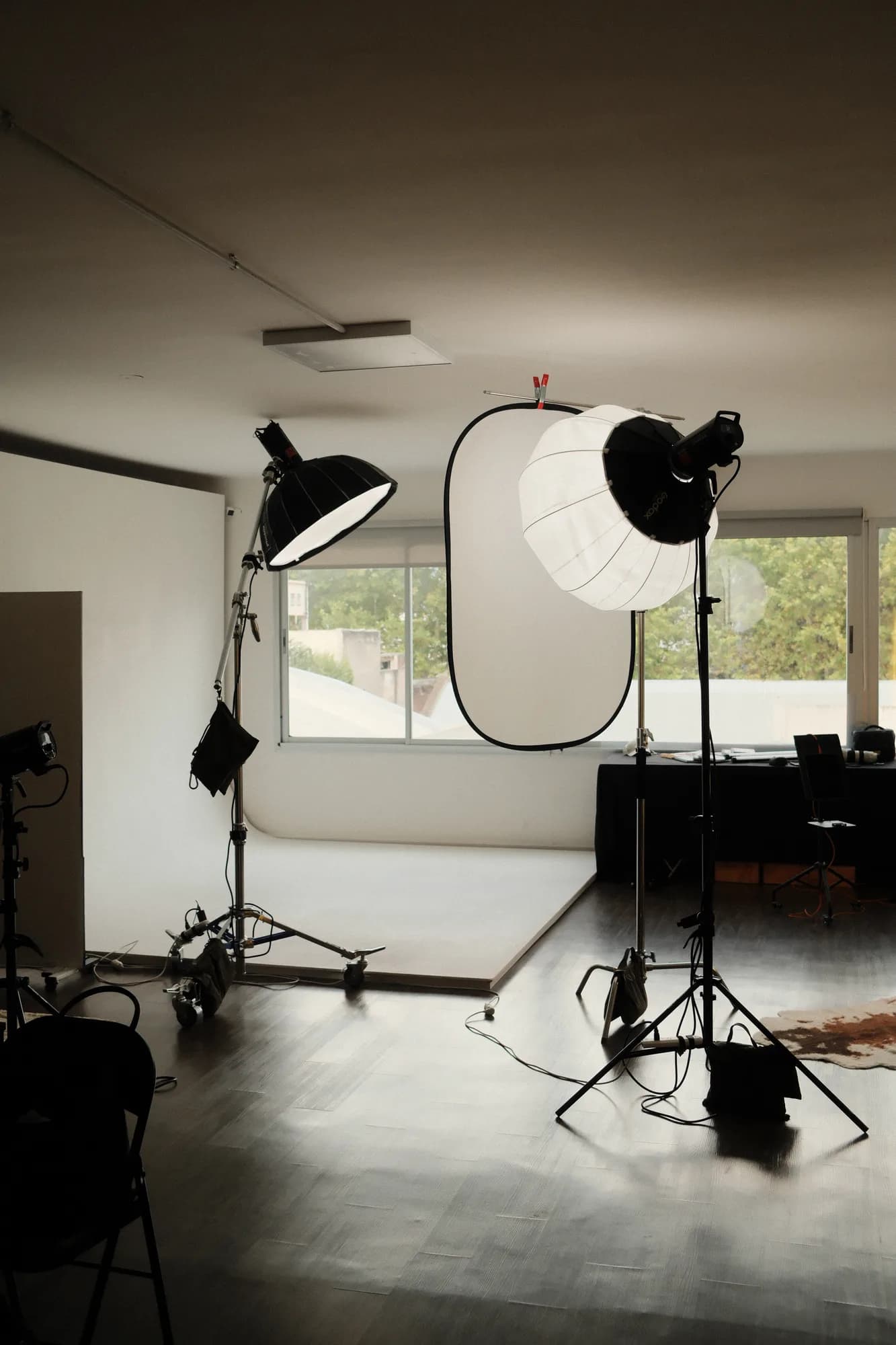 El estudio con el ciclorama, el paraguas y los flashes frente a los ventanales