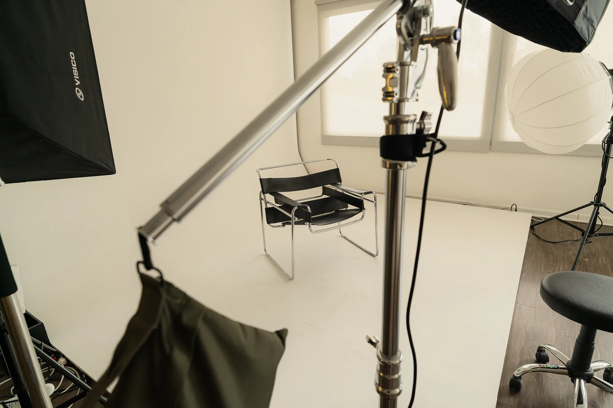 Una silla de cuero sobre el ciclorama, entre el brazo del flash y el softbox