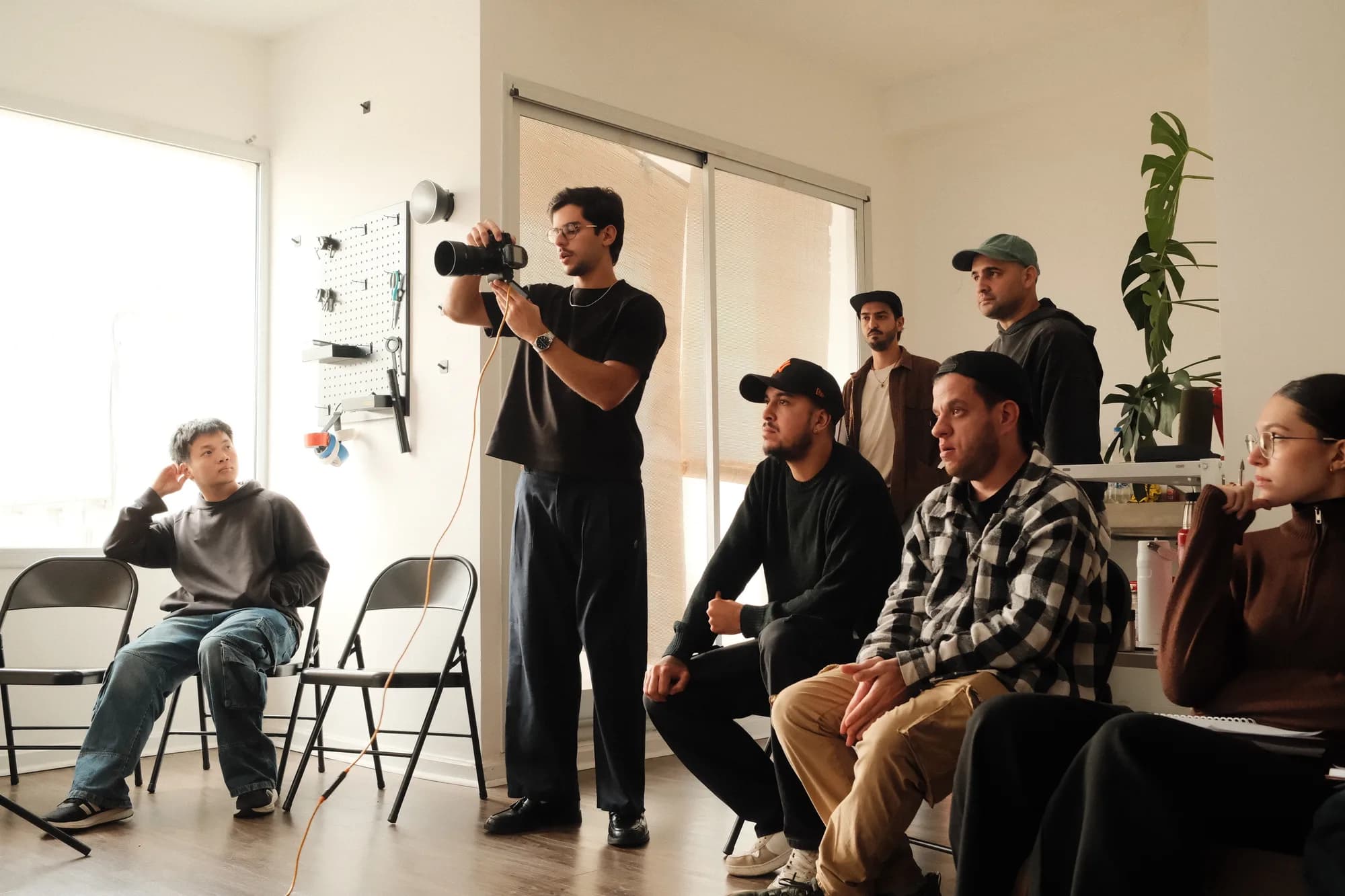 Rodrigo fotografiando de pie durante una clase, con los alumnos sentados alrededor