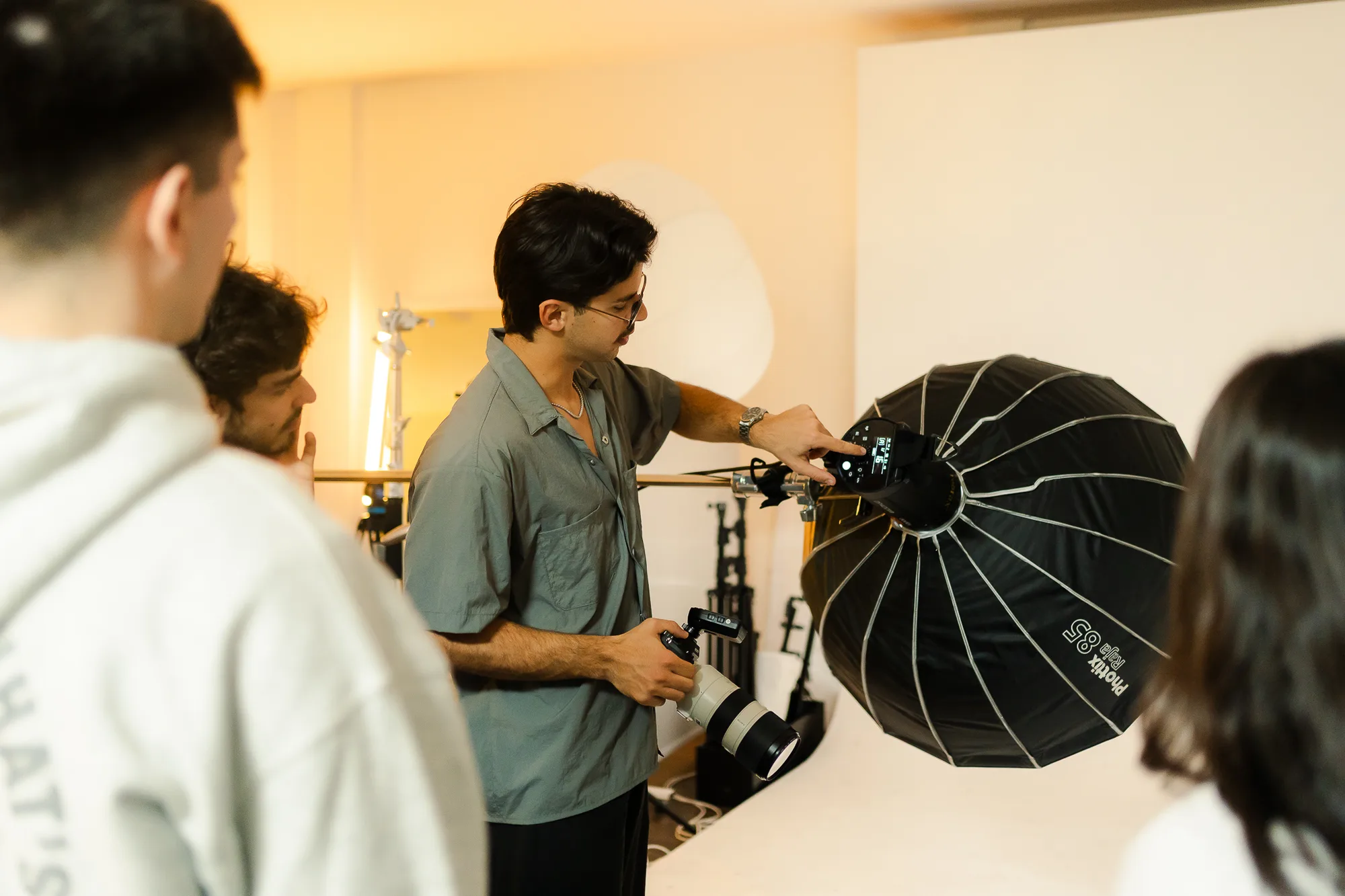 Rodrigo acomoda un softbox en el set, con alumnos alrededor