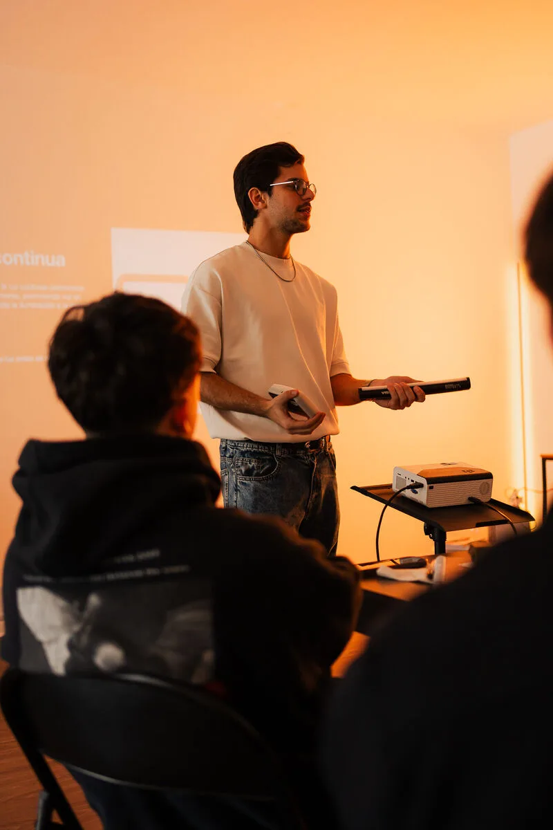 Rodrigo dando la charla con luz cálida, con alumnos en primer plano