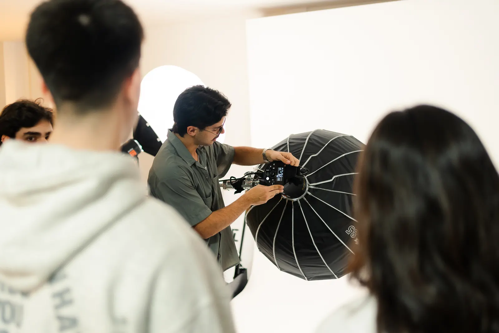 Rodrigo acomoda un softbox con alumnos alrededor